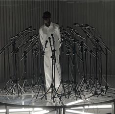 a man standing in front of a bunch of microphones