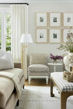 a living room filled with furniture and pictures hanging on the wall above it's windows