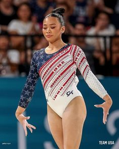 a woman is performing on the balance beam