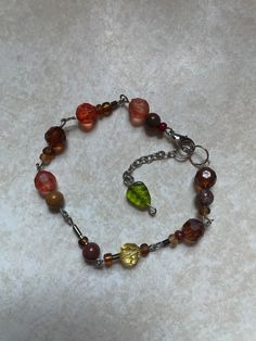 A bracelet primarily containing brown and orange glass beads. Adjustable from about 8 inches to 9 inches. Also has a cute green leaf bead:) Brown Beaded Bracelets, Aesthetic Bracelets Beads, Glass Beads Bracelet, Diy Beaded Rings, Bracelet Inspo, Earthy Jewelry, Diy Jewelry Unique, Brown Bracelet, Brown And Orange