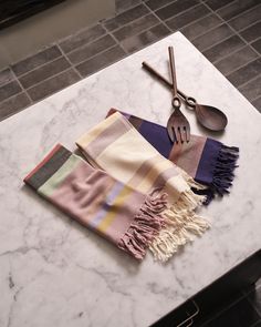 a kitchen counter with utensils, spoons and a towel on top of it