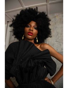 a woman with an afro in a black dress