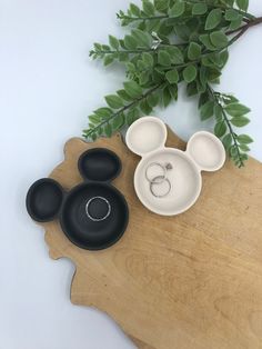 mickey mouse ring dish with matching black and white dishes on a wooden tray next to a green plant