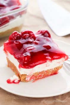 a piece of cheesecake with cherries on top is sitting on a white plate