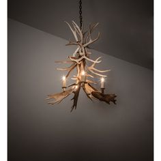 a chandelier with antlers hanging from it's sides and two candles in the middle