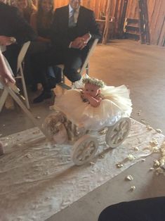 a baby in a carriage being walked down the aisle