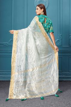 Look royal on weddings and festive occasions in this beautiful white tissue silk saree. It comes with a green bandhej saree blouse. White Cotton Silk Pre-draped Saree For Festivals, White Cotton Silk Pre-draped Saree With Zari Work, White Pre-draped Saree With Gota Work For Navratri, White Tissue Silk Pre-draped Saree With Unstitched Blouse, White Tussar Silk Pre-draped Saree For Diwali, White Art Silk Pre-draped Saree For Festivals, Transitional White Saree With Sheer Dupatta, Transitional White Silk Pre-draped Saree, White Silk Pre-draped Saree For Festivals