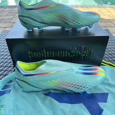 a pair of soccer cleats sitting on top of a table next to a shoe box