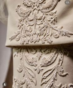 the back of a white dress with an intricate design