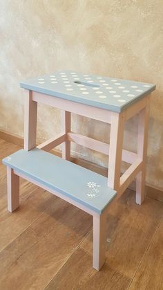 a blue and white bench sitting on top of a hard wood floor next to a wall