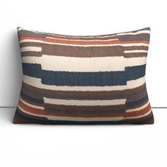 a brown and blue pillow sitting on top of a white wall