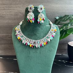 Anvi Multicolor Silver Polki Necklace Set with Maangtikka. Expertly crafted with precision and intricate detailing, the Anvi Multicolor Silver Polki Necklace Set with Maangtikka is a must-have statement piece for any occasion. The stunning multicolor stones and shimmering silver polki add a touch of elegance and sophistication to any outfit. Elevate your style and make a bold statement with this exquisite jewelry set. Multicolor Hand Set Bridal Necklace, Multicolor Temple Jewelry With Jewels, Hand Set Multicolor Bridal Necklace, Fusion Style Multicolor Bridal Necklace For Party, Multicolor Fusion Bridal Necklace For Party, Multicolor Jeweled Kundan Necklace For Party, Multicolor Stones Jewelry For Celebrations, Multicolor Stone Jewelry For Celebration, Traditional Multicolor Jewels Necklace