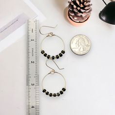 These gold hoops, adorned with black jasper beads, add a touch of eclectic elegance to any outfit. Perfect for any boho babe, these earrings are a must-have for your collection. 14k Gold Filled Wire Measure approximately 1.125" in diameter Earrings Hang 1.75" from top of ear wire Black Jasper Gemstones Polished to a high shine Sent in a Gift Box with Polishing Cloth Handmade in Montana Bohemian Jewelry With Black Beads, Round Shape, Bohemian Jewelry With Black Round Beads, Bohemian Jewelry With Black Beads, Handmade Black Jewelry For Everyday, Black Handmade Jewelry For Everyday, Handmade Black Everyday Jewelry, Bohemian Black Beaded Jewelry, Everyday Round Onyx Jewelry, Nickel Free Hoop Beaded Earrings For Everyday