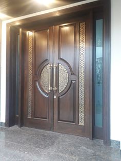 a large wooden door with intricate carvings on the side and glass panels at the top