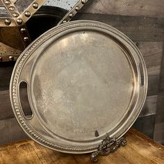 an ornate silver tray sitting on top of a wooden table