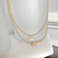 This Logo Ball Chain Gold Necklace brings a modern twist to a timeless classic. Its signature logo charm sits atop a water-resistant gold ball chain, creating a sophisticated and exclusive accessory perfect for making a statement and displaying unique style. Measures 16” Logo charm is 14 karat gold filled. Choose small ball chain or medium ball chain size. Comes boxed. Made in USA. Gold Metal Ball Chain Necklace, Gold-plated Ball Chain Necklace, Perfect As A Gift, Everyday Gold Ball Chain Necklace, Minimalist Gold Necklace With Ball Chain, 14k Gold Filled Ball Chain Necklace, Dainty Gold Ball Chain Necklace, Gold Plated Charm Necklaces With Satellite Chain, Gold-plated Gold Charm Necklace With Satellite Chain, Gold Plated Gold Charm Necklace With Satellite Chain