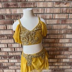 a mannequin wearing a yellow top and skirt with gold sequins on it