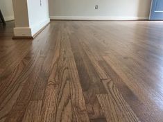 an empty living room with hard wood flooring