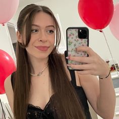 a woman taking a selfie in front of balloons