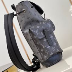 a louis vuitton backpack sitting on top of a white table with flowers in the background