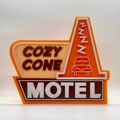 an orange motel sign sitting on top of a white wall