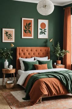 a bedroom with green walls, orange bedding and pictures on the wall above it