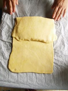 a person is kneading dough on a piece of paper that has been rolled out