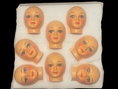 six plastic heads with different facial expressions on them