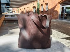 Color and texture are the most important things in this bag. The color is dark brown, the color of dark chocolate. It is a natural genuine leather. The leather is embossed with asnake. The bag is a medium-sized shopper. The bag has an outer pocket on the back - zippered. The bag easily fits A4, but will not overwhelm the figure. Details: -natural leather with snake embossing - color - dark brown -closure of the bag with a zipper - an outer zippered pocket on the back -Inside lining, zip pocket a Luxury Tan Bags For Gift, Large Luxury Brown Satchel, Luxury Large Capacity Shoulder Bag As Gift, Brown Textured Leather Shoulder Bag For Daily Use, Luxury Shoulder Bag With Large Capacity As Gift, Brown Textured Leather Bag For Daily Use, Large Elegant Brown Shoulder Bag, Brown Textured Leather Tote Shoulder Bag, Brown Square Shoulder Bag As Gift