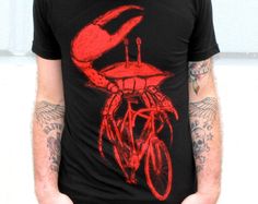 Dark Cycle Clothing Custom Screen Printed Mens Black T-shirt The underwater emissions were becoming of concern for sea predators so when the shark decided to stop fussing and start a revolution he was soon followed by a deluge of whales, octopi, and now crabs. This Dark Cycle exclusive is screen printed with the bright red discharge ink on a super soft standard black 100% cotton t-shirt. Printing with discharge is a process that dyes the shirt, rather than laying ink on top, so after the first w Crab Shirt, Riding A Bicycle, Dachshund Shirt, Tshirt Custom, Custom Screen Printing, Bike Shirts, Cycling Outfit, Unisex Shirts, Unisex Shirt