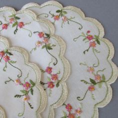 four white doily with pink flowers on them