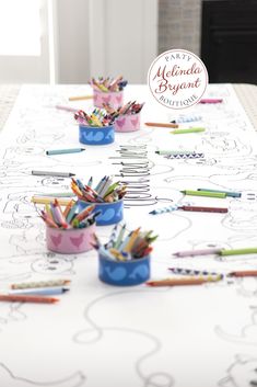 pencils and crayons are sitting in cups on a table