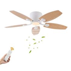 a person holding a remote control in front of a ceiling fan that is flying through the air