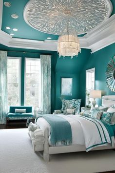 a bedroom with teal walls and white bedding, chandelier above the bed