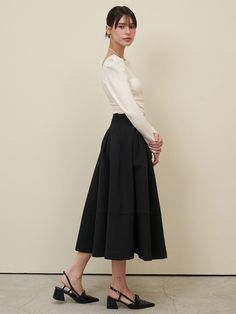 This product is a Shell Skirt that offers a sophisticated and timeless look. The piece is designed with a high waist and a flared silhouette that gracefully sweeps to a mid-calf length. Its paneled construction and discreet pockets blend functionality with elegance, making it a versatile addition to any wardrobe. - The skirt's high waist design accentuates the figure while providing a classic, polished appearance.- A flared silhouette and mid-calf length give the skirt a graceful flow and versatile style.- Paneled construction not only adds a subtle design element but also ensures a flattering fit.- Equipped with pockets, the skirt combines practicality with its refined aesthetic. Modern A-line Skirt For Workwear, Elegant A-line Bottoms For Evening, Chic A-line Pleated Skirt, Chic A-line Maxi Skirt With Relaxed Fit, Chic A-line Maxi Skirt For Work, Modern Full Skirt Fitted, Modern Fitted Full Skirt, Chic Long Pleated Skirt For Fall, Elegant Flared Skirt For Fall