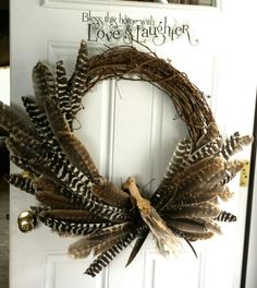 a wreath made out of feathers on the front door to say i love you and laughter