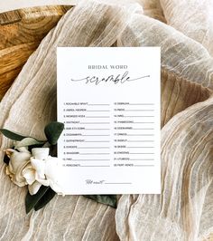 a bridal word scramble on top of a blanket with flowers and greenery around it