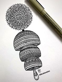 an ink drawing of a flower with circles and dots on it, next to a marker pen