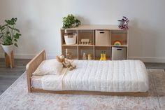 The oak montessori floor bed with one headboard and a six cube shelf in the background Low Floor Bed, Floor Bed Toddler, Wooden Toddler Bed, Bed Handles, Kids Floor Bed, Room Sharing, Modular Bed, Low Profile Bed Frame, Kid's Bed