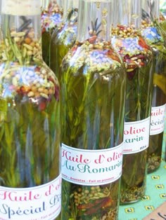 several bottles filled with flowers and seeds on top of a table next to each other