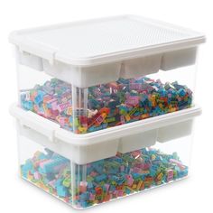 two plastic storage containers filled with colorful legos on top of each other in front of a white background