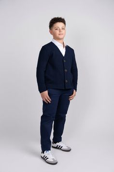 Introducing our Navy Chunky Knit Cardigan – the perfect blend of style, warmth, and comfort for your young trendsetter. The rich navy hue complements any outfit, making it a versatile addition to his wardrobe for both casual and semi-formal occasions. Featuring a classic design, this cardigan is adorned with large brown buttons that not only serve as functional closures but also add a charming contrast to the deep navy fabric. Navy Cotton Cardigan For Winter, Navy Cotton Winter Cardigan, Navy Cotton Cardigan For Fall, Navy Knit Outerwear For Winter, Navy Knit Winter Outerwear, Navy Casual Peacoat For Fall, Navy Textured Knit Sweater For Fall, Classic Blue Knit Outerwear, Casual Navy Cardigan For Fall