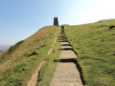 a long set of steps leading up to the top of a grassy hill on a sunny day