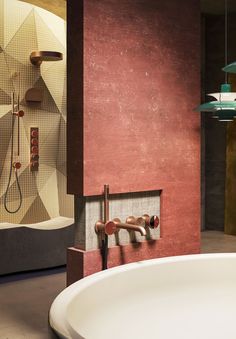 a bath tub sitting next to a wall mounted shower faucet in a bathroom