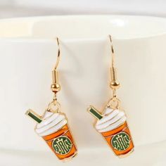 a pair of earrings with a drink in the shape of a starbucks cup on it