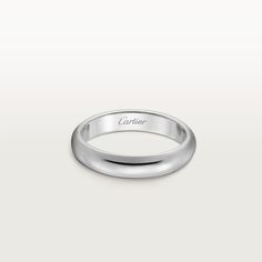 a white gold wedding band with the name cartier engraved on it