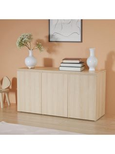 two vases on top of a wooden cabinet in a room with orange walls and white furniture