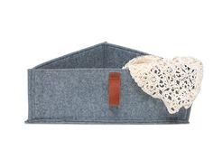 a white doily is placed on top of a blue felt bag with a leather tag