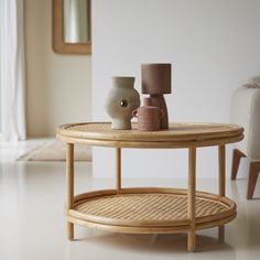 a coffee table with two vases on it and a mirror in the back ground