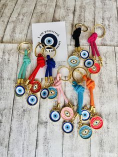 several key chains with evil eyes on them and a book in the middle one has an eye charm attached to it